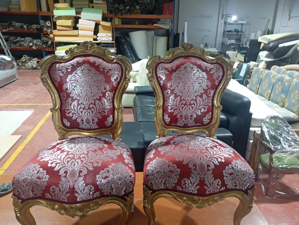 Dos sillas isabelinas de madera dorada retapizadas en damasco rojo y blanco